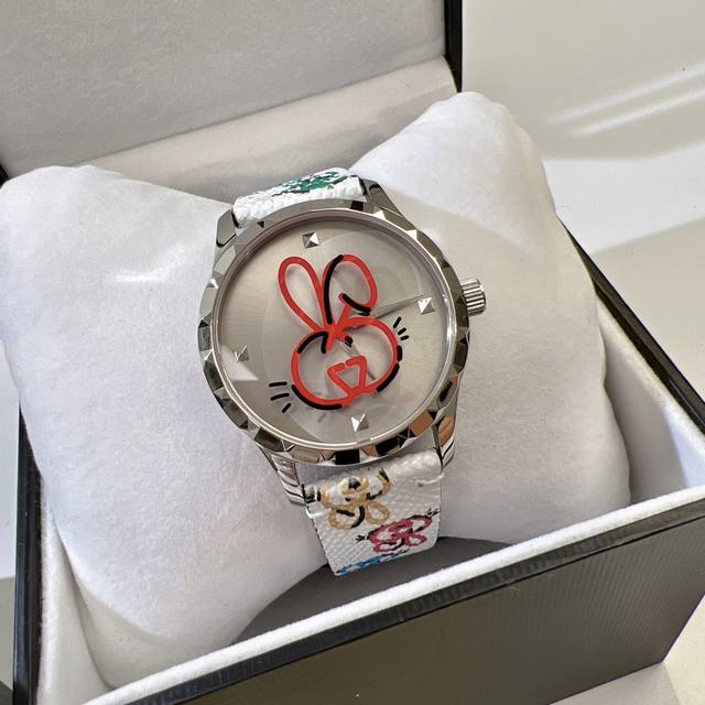 Gucci G Timeless 系列w碗表 为了庆祝兔年 品牌推出色彩靓丽的全新设计腕表 表盘直径为38 mm 精钢表壳 玻璃上饰有Gucci兔子印花 皮 革